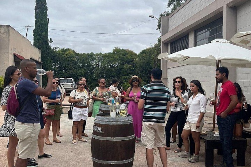 A group of people standing around a barrel with a label that reads 'LITRATOR.' 2