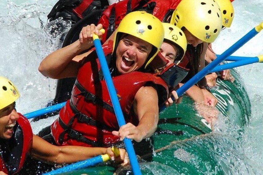 People in a raft wearing helmets and life jackets. 2