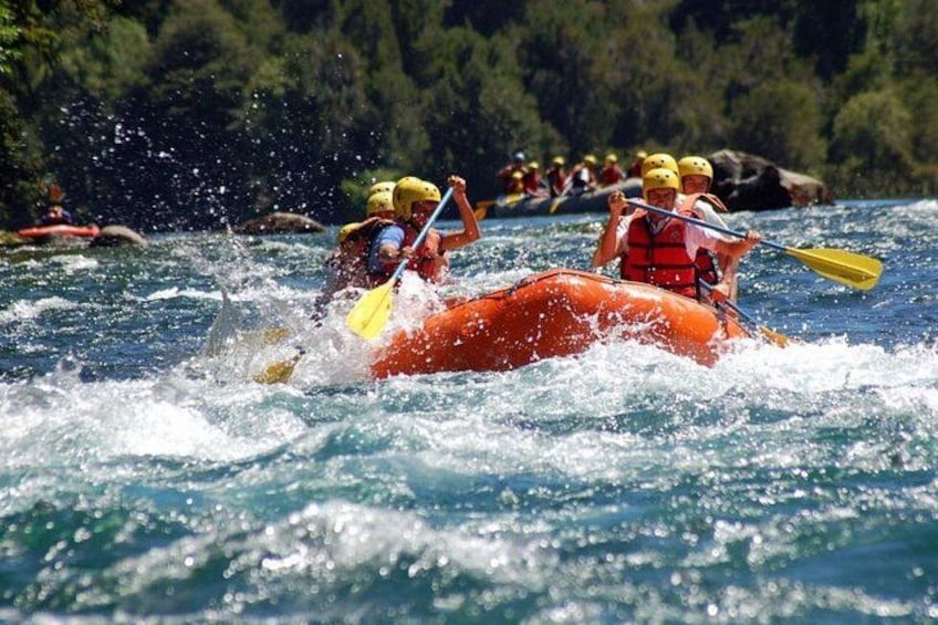 A group of people kayaking on a river surrounded by greenery. 1
