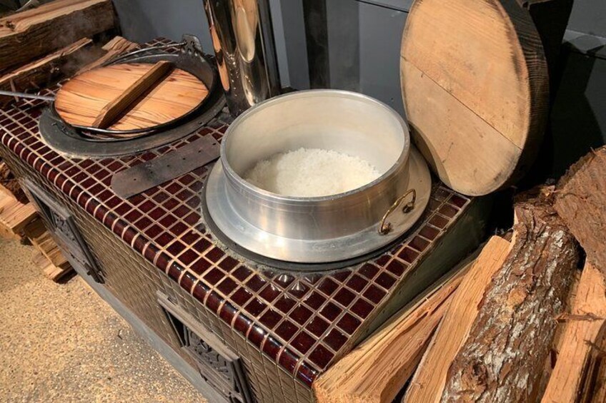 A wood-fired stove with a pot of rice on top. 3