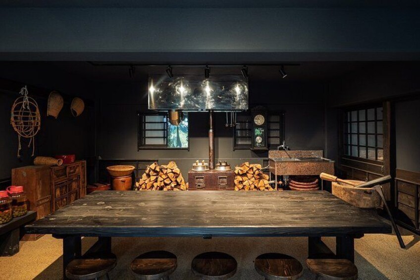 A rustic kitchen with a large wooden table, hanging baskets, and a clock on the wall. 5