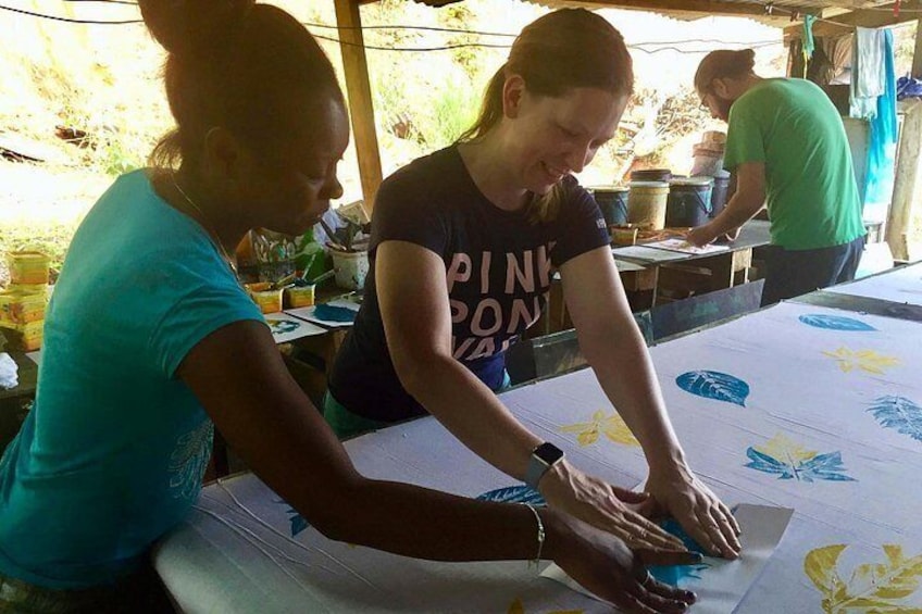 Two people working on a large sheet with leaf patterns. 3