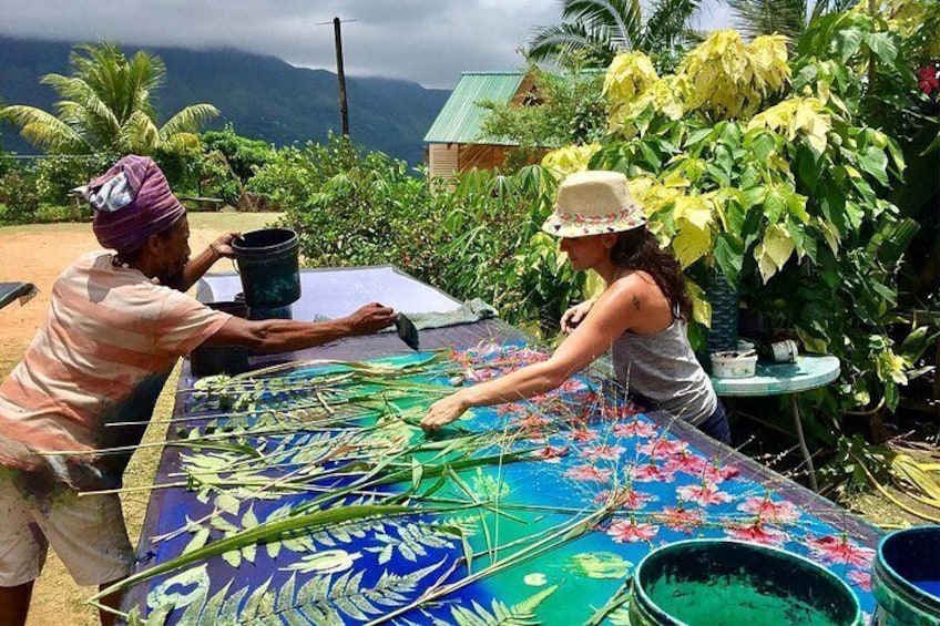 Two people painting a large table with floral patterns. 2