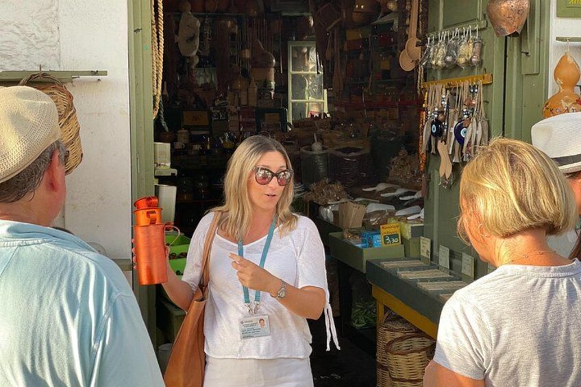 A person standing at a market stall with various items on display. 3