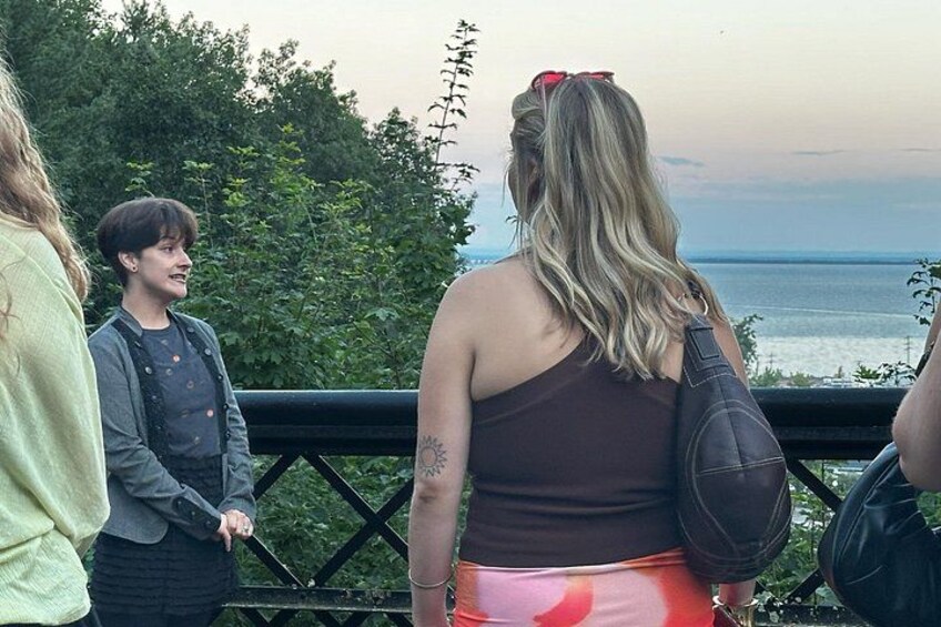 A group of people standing on a bridge overlooking a body of water. 3