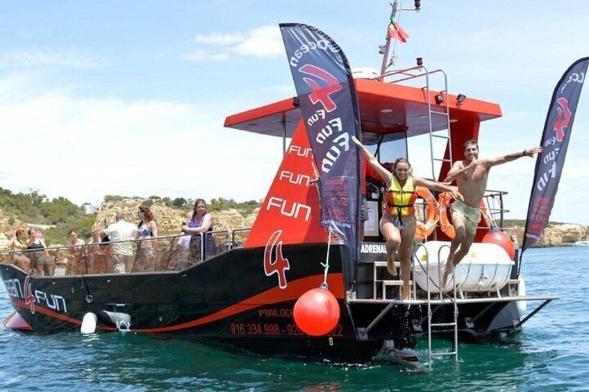 Un bateau rouge et noir avec des personnes à bord, une bouée de sauvetage et un drapeau. 5
