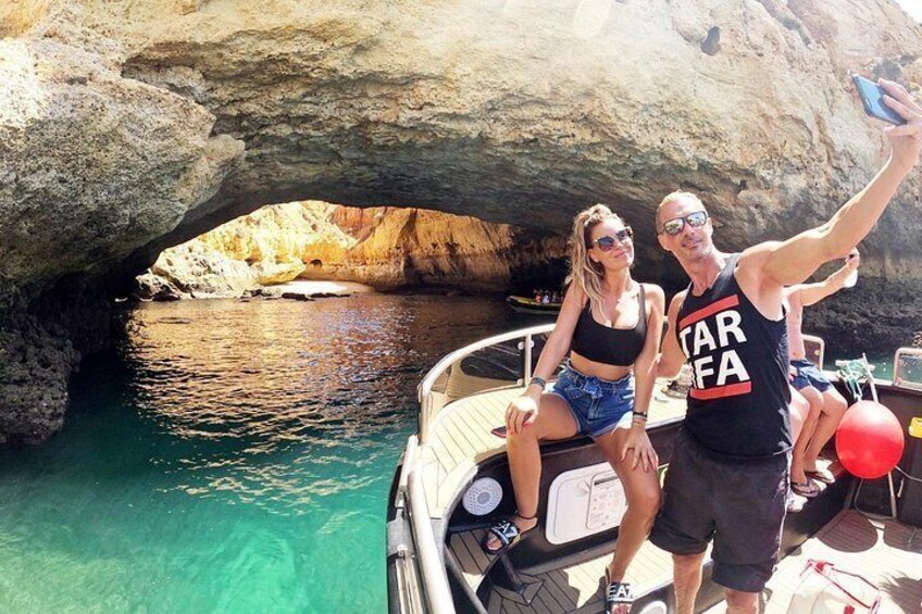 Un bateau avec deux personnes prenant un selfie devant une formation rocheuse. 3