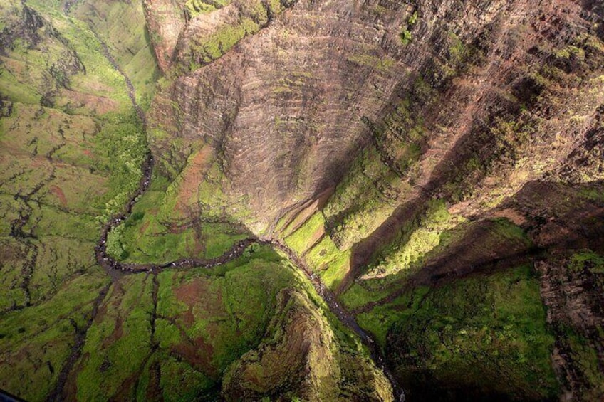 A river winding through a valley with green vegetation and steep, rocky terrain. 5