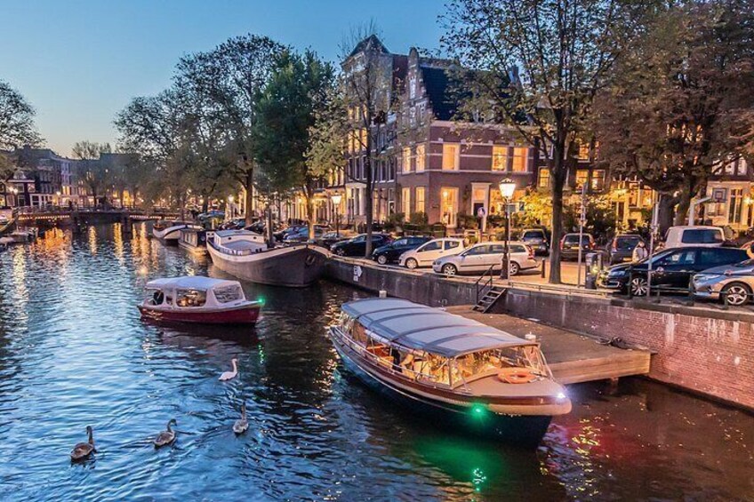 A canal with boats, ducks, and buildings along the water. 2