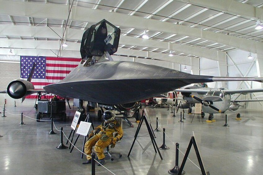 A military aircraft on display with an American flag in the background. 2