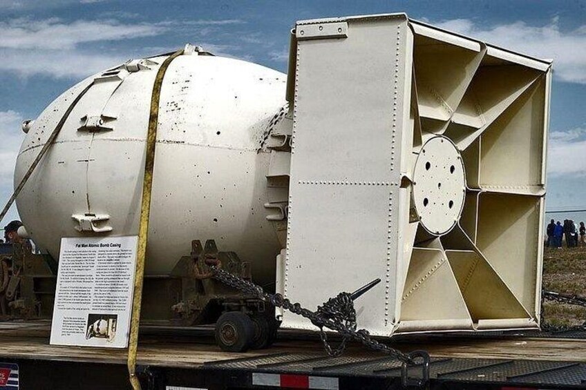A large industrial tank truck parked on a flatbed trailer with a yellow tarp covering it. 5