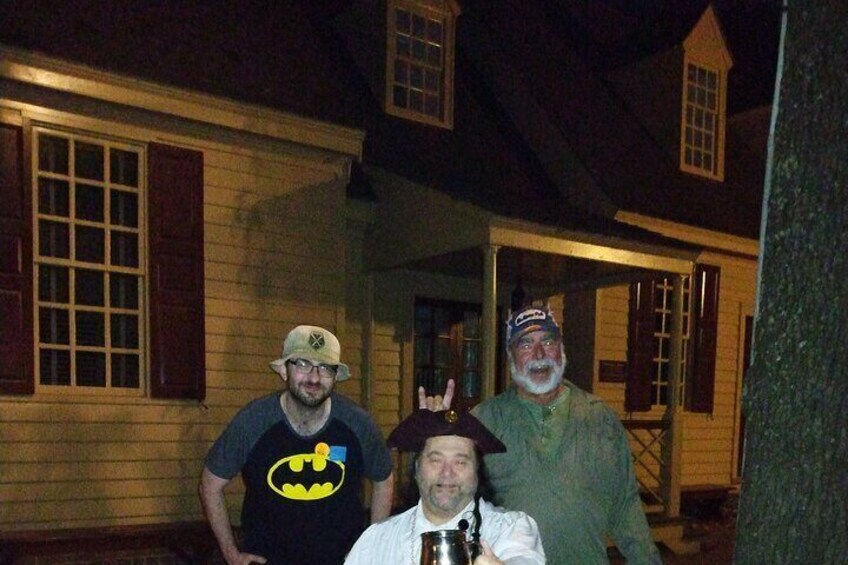 Tres personas frente a una casa por la noche. 4