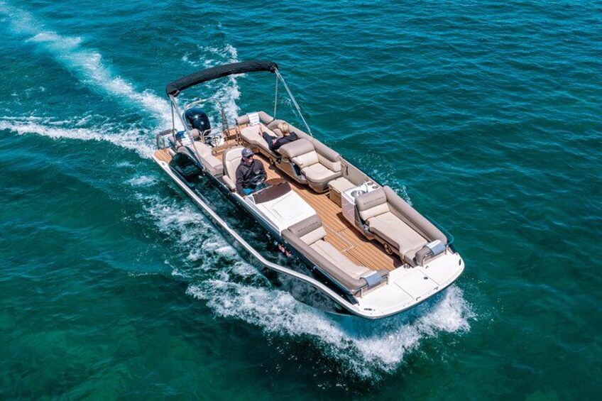 A speedboat with a covered top, multiple seating areas, and a wake behind it. 1