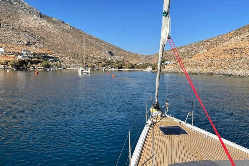 A sailboat on a calm lake with a mountainous backdrop. 2