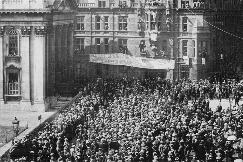 Una multitud se reunió frente a un edificio con un cartel. 3
