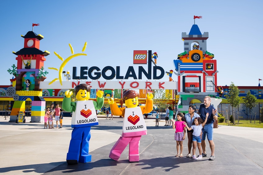 Letrero de LEGO Nueva York, figuras de LEGO y una familia frente a él. 1