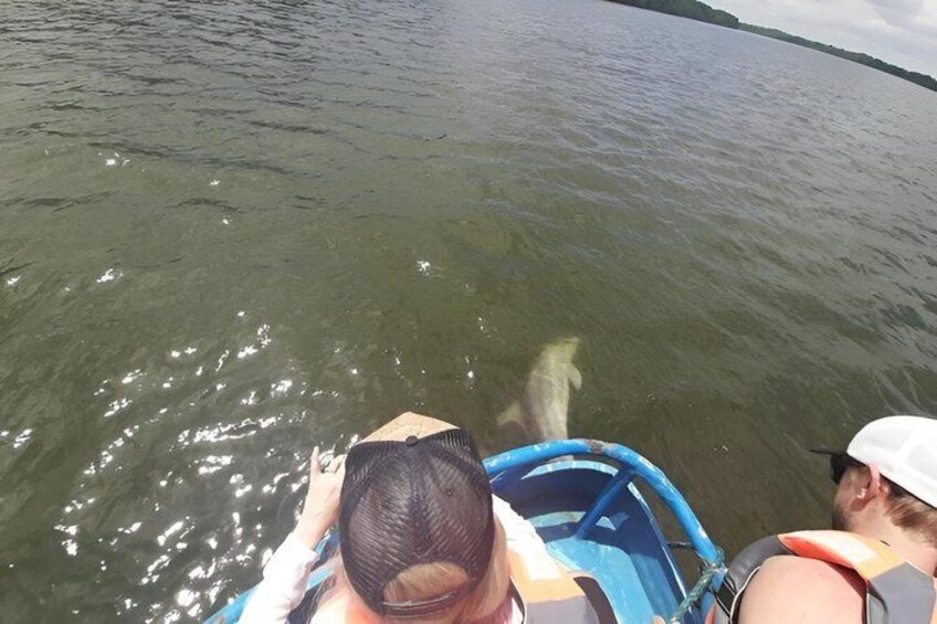 A boat on a body of water with a person wearing a life jacket. 1