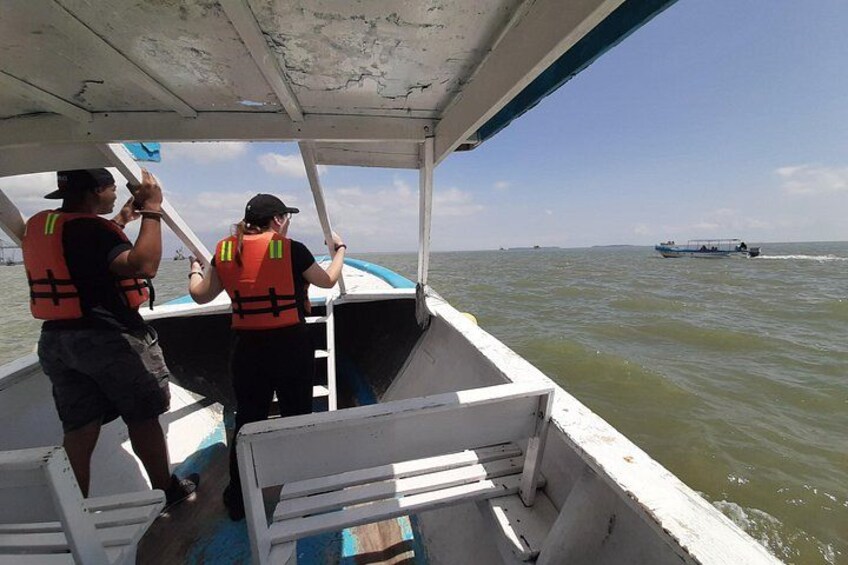 Two people on a boat wearing life jackets, looking out at the water. 5