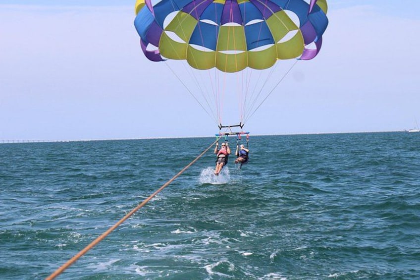 Une personne pratiquant le parasailing avec un parachute aux couleurs vives au-dessus de l’océan. 5