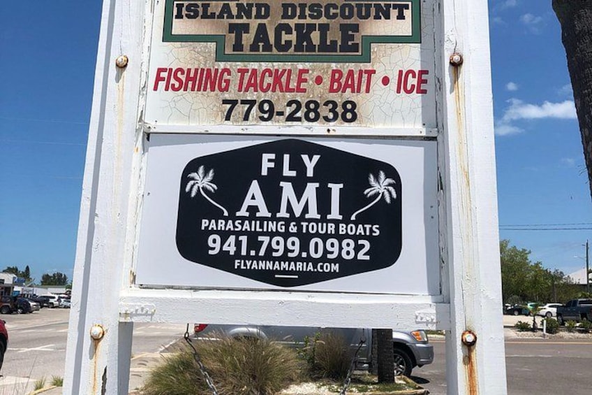 Un panneau publicitaire comportant deux annonces : l’une pour Island Discount Tackle et l’autre pour Fly Ami Parasailing & Tour Boats. 2