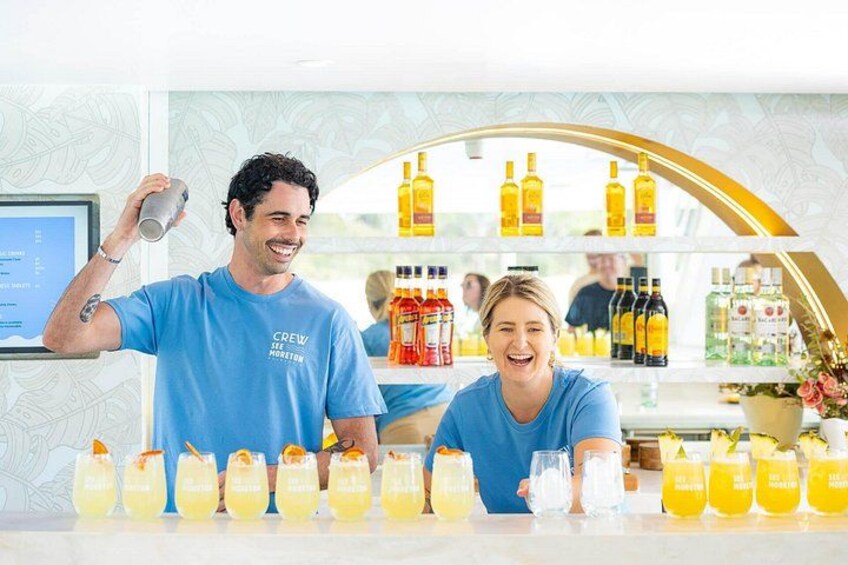 A bar setting with a bartender and a customer, a counter with drinks, and a display of liquor bottles in the background. 3