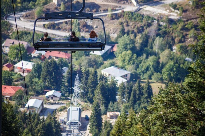 A cable car with passengers, a mountainous landscape, and a power line tower. 3