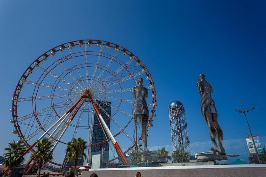 A Ferris wheel, two tall sculptures, and a modern building. 4