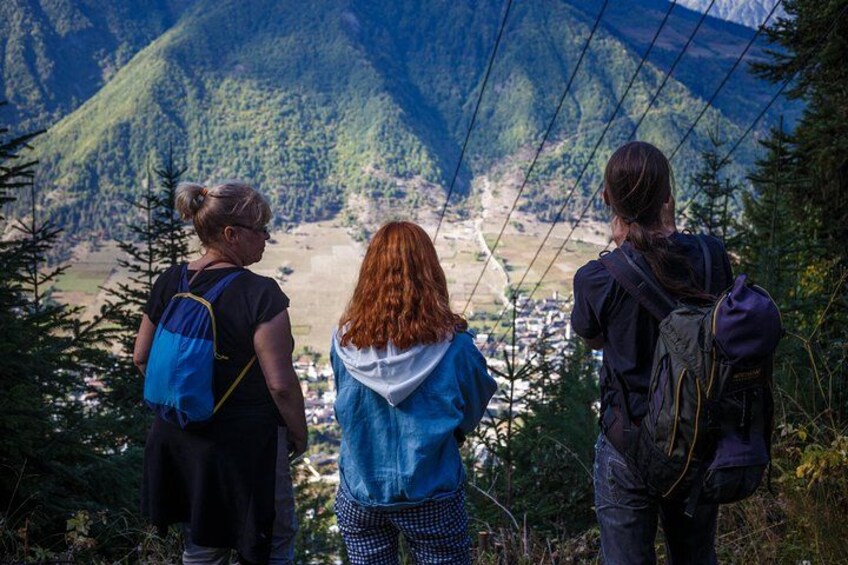 Tres personas caminando por un sendero de montaña, con un valle al fondo. 2