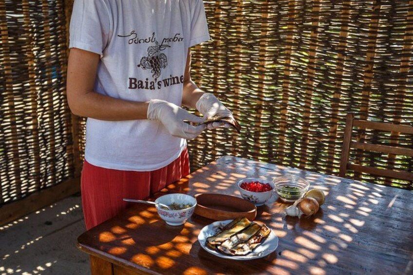 A person preparing food outdoors with a wicker table and various bowls and plates. 4
