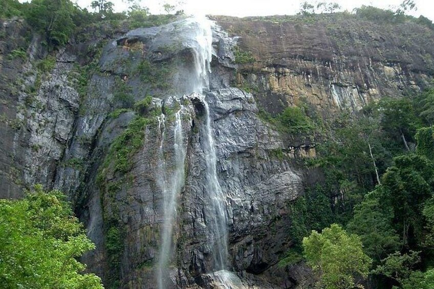 A waterfall cascading down a rocky cliff surrounded by lush greenery. 4