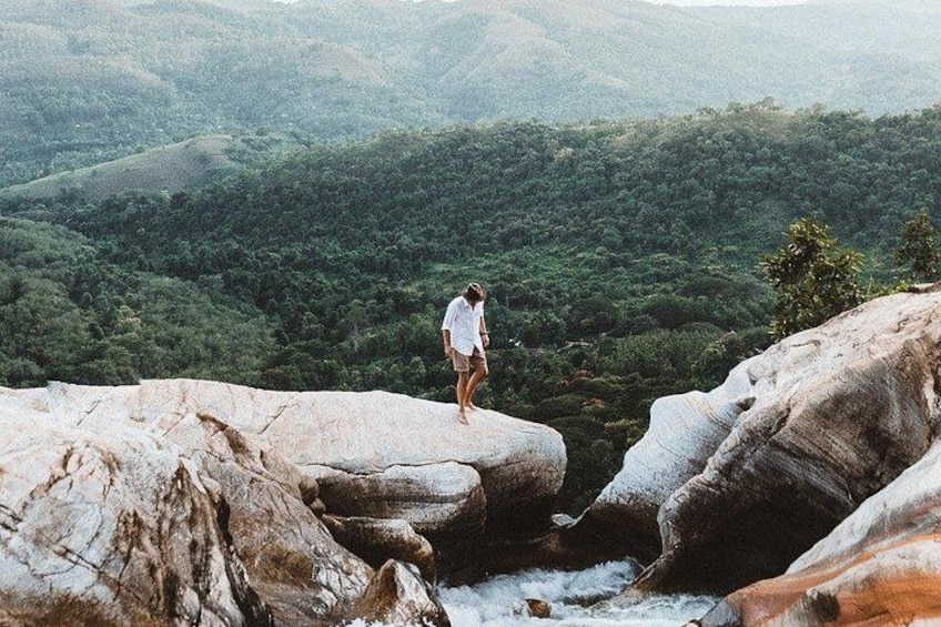 A person standing on a rock overlooking a valley. 1
