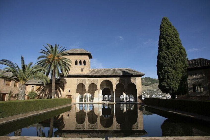 A historic building with arches, palm trees, and a clear sky. 4