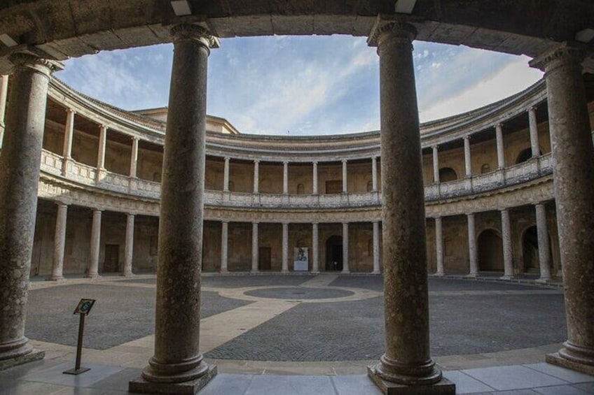 A circular courtyard with columns, a central open space, and a tiled floor. 2
