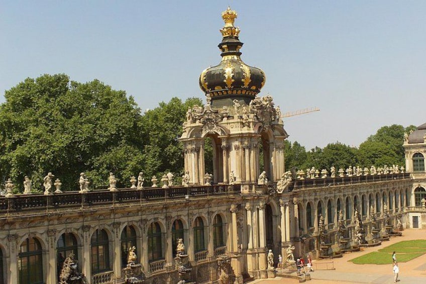 A grand palace with ornate architecture, including a large dome and statues lining the walkway. 3