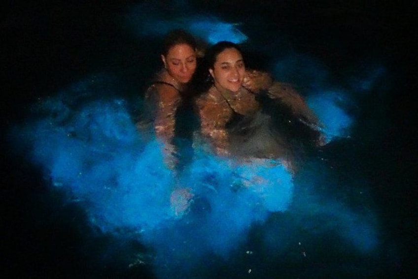 Two people in a body of water with blue lighting effects. 2