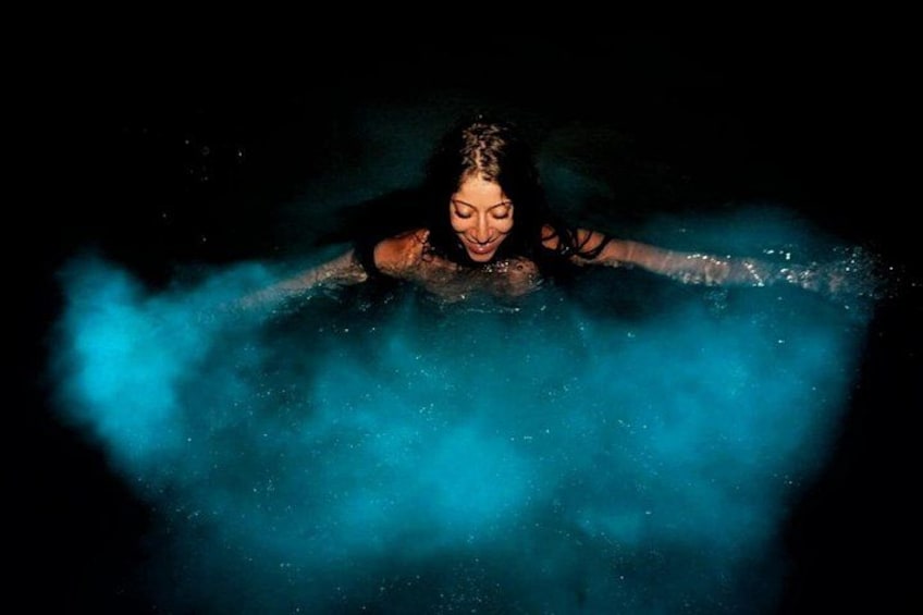 A person submerged in water with blue smoke or mist around them. 1