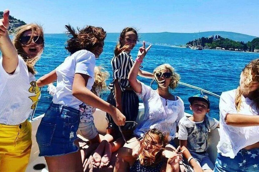 A group of people on a boat with a body of water and a distant shoreline in the background. 4