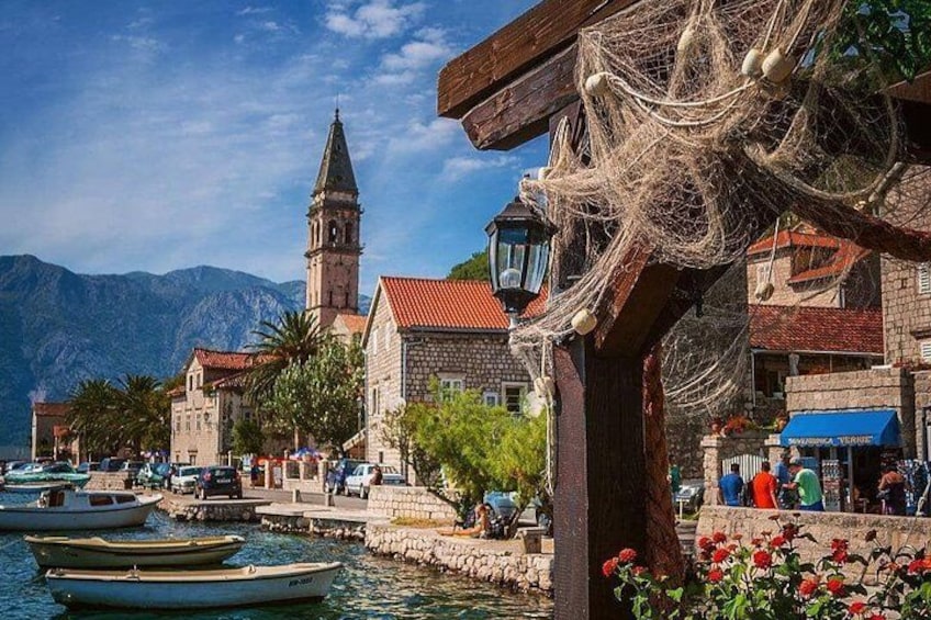 Une ville côtière avec des bateaux, une église et des montagnes en arrière-plan. 4