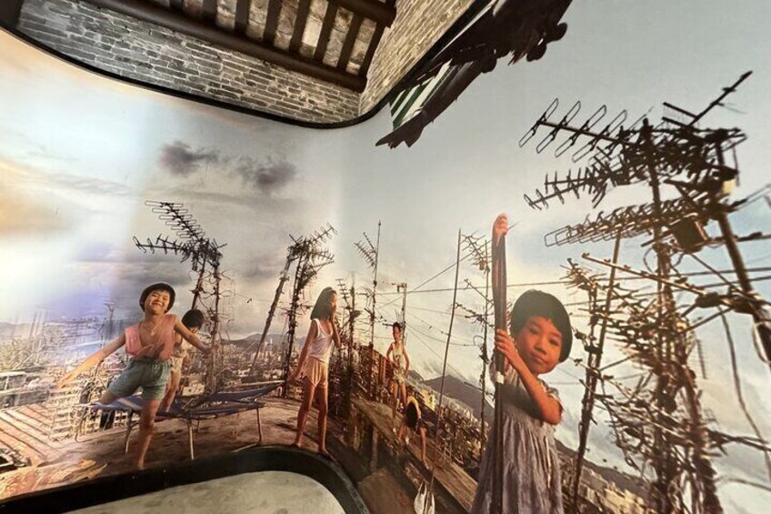 A mural with figures on a bridge, antennas, and a cityscape in the background. 4