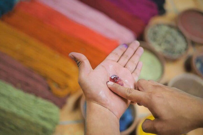 Une personne applique une pâte colorée sur la main d’une autre personne. 5