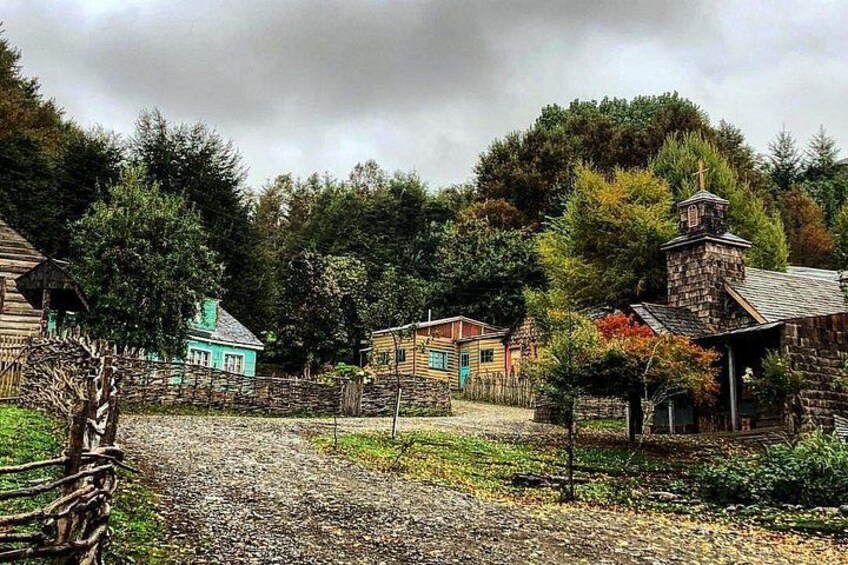 Un village rural avec des maisons en bois, une église en pierre et un chemin de terre. 4