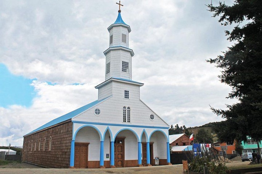 Une église blanche aux ornements bleus, dotée d’un clocher. 5