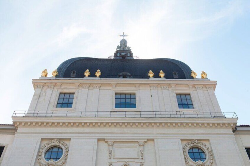 A building with a dome and statues on top. 5