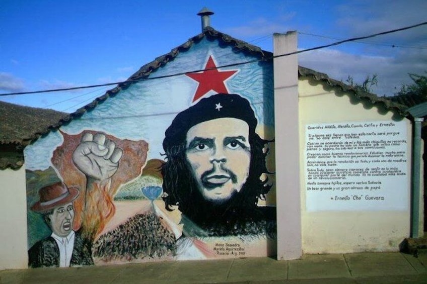 A mural with a raised fist, a star, and a portrait. 2