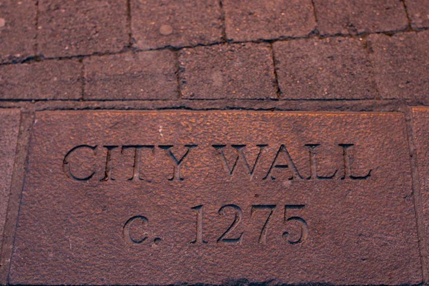 A brick pavement with the inscription 'CITY WALL c. 1275'. 4