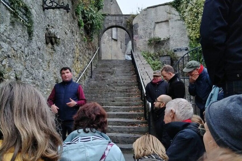 Een groep mensen loopt een stenen trap op in een historische omgeving. 2