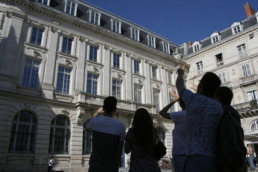 A group of people taking a photo in front of a historic building with classical architecture. 4