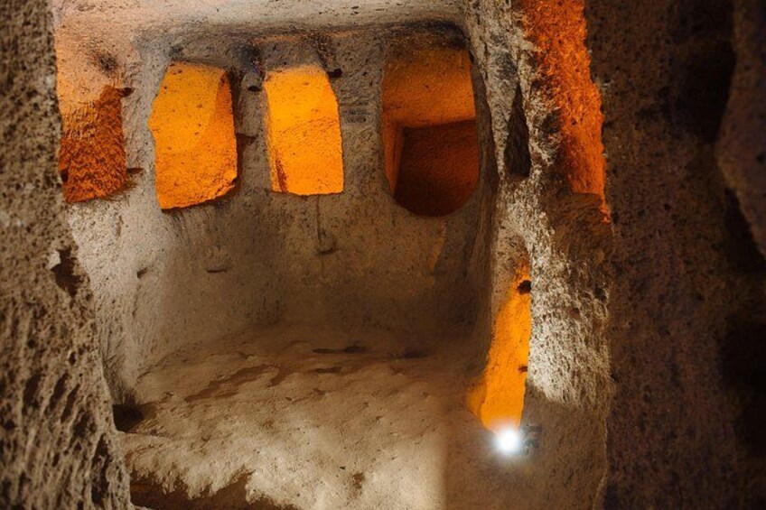 Eine Höhle mit orangenen Felsformationen und einer kleinen Öffnung. 4
