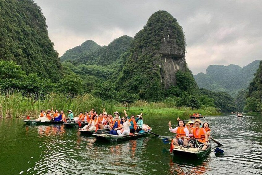 Un gruppo di persone su barche in un fiume, circondato da vegetazione rigogliosa e scogliere rocciose. 2