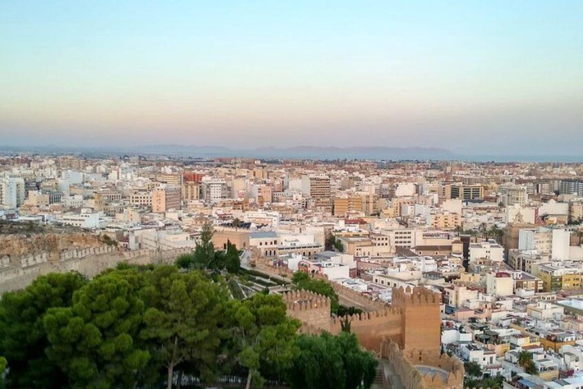 Une vue urbaine avec un mur imposant et des arbres au premier plan. 2